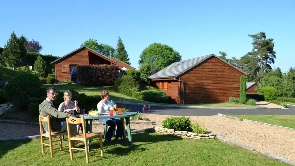 Chalets en bois du domaine Volcans Vacances — terrasse d'été au bord du lac d'Aydat